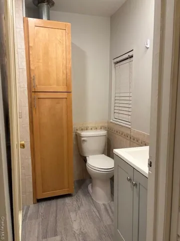 a bathroom with a toilet a sink and a window