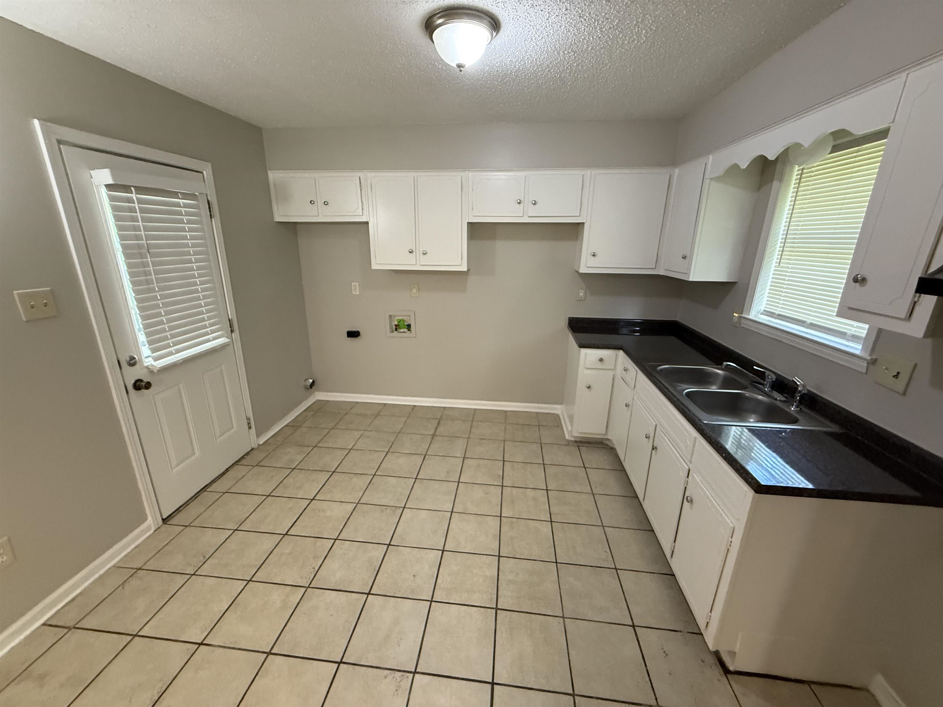 4213 Cochese Road Memphis, TN 38118 - Photo 3 of 11 Kitchen with a textured ceiling, dark countertops, white cabinets, and light tile patterned flooring