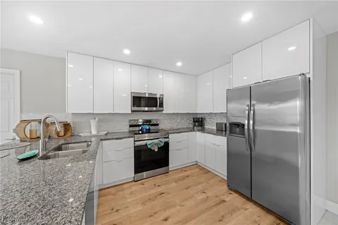 a kitchen with granite countertop a refrigerator sink and stove