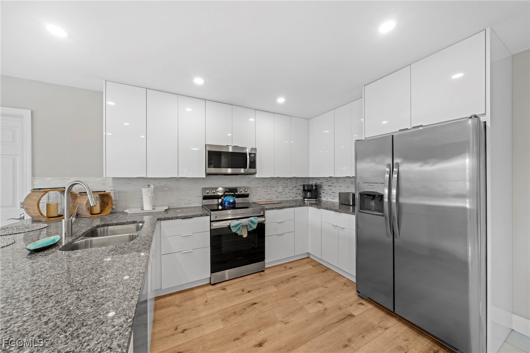 5303 Southwest 26th Court Cape Coral, FL 33914 - Photo 11 of 45 a kitchen with granite countertop a refrigerator sink and stove