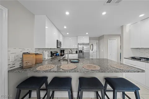a kitchen with a dining table chairs stove and refrigerator