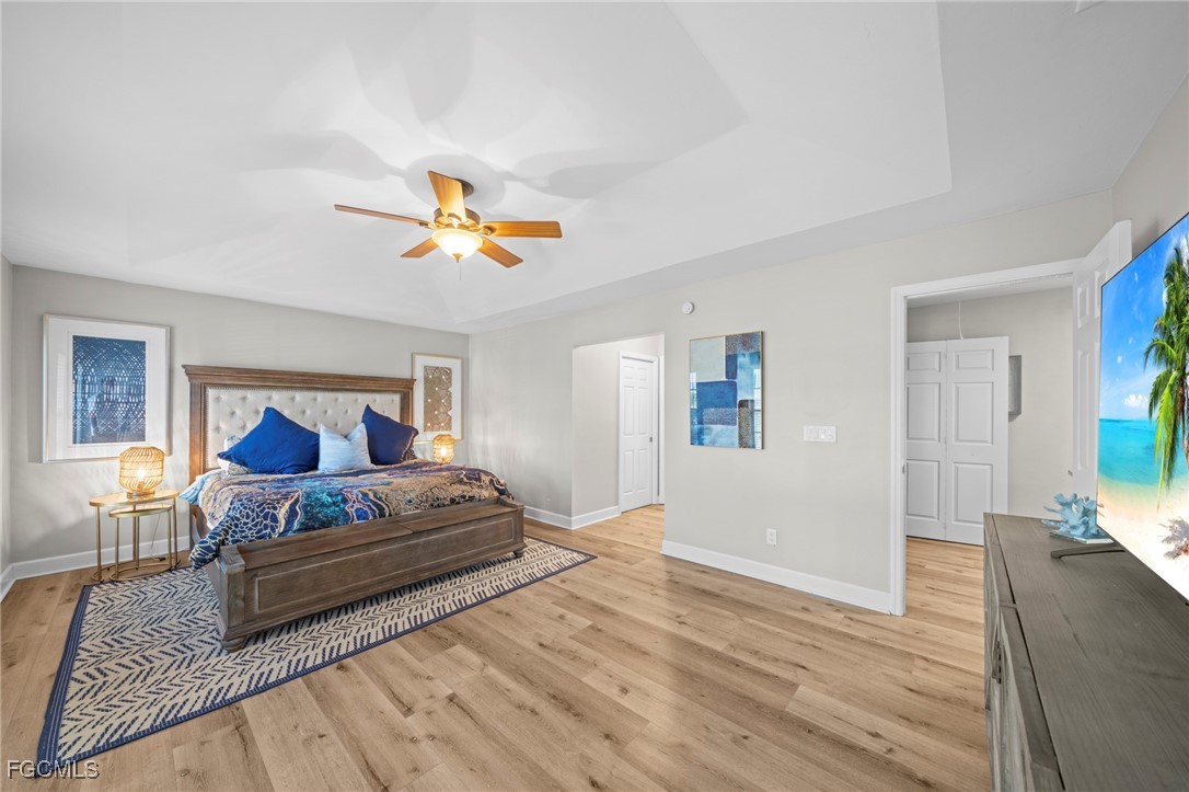 5303 Southwest 26th Court Cape Coral, FL 33914 - Photo 17 of 45 a bedroom with a large bed and a chandelier