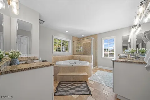 a bathroom with a granite countertop sink a mirror and a bathtub