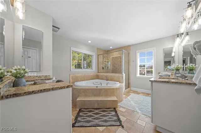 a bathroom with a granite countertop sink a mirror and a bathtub