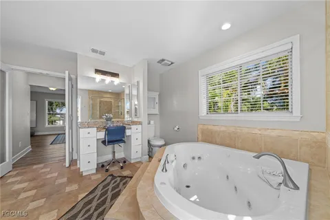 a bathroom with a bathtub and a wooden floor