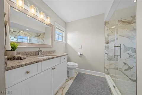 a bathroom with a granite countertop sink toilet and shower