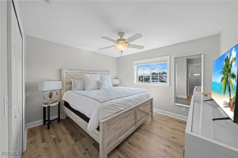 a bedroom with a bed and a flat tv screen on dresser