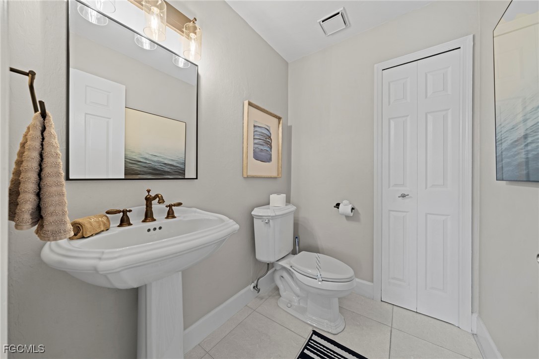 5303 Southwest 26th Court Cape Coral, FL 33914 - Photo 25 of 45 a bathroom with a toilet sink and mirror