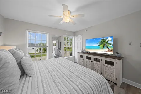 a bedroom with a bed and a flat tv screen on dresser