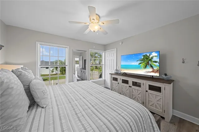 a bedroom with a bed and a flat tv screen on dresser