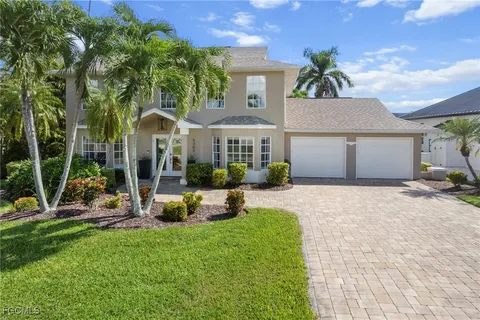 a front view of a house with a yard and potted plants