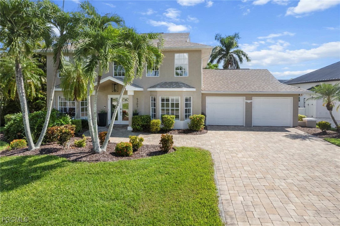 5303 Southwest 26th Court Cape Coral, FL 33914 - Photo 41 of 45 a front view of a house with a yard and potted plants