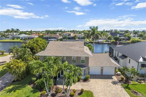 a aerial view of a house with a yard and lake view in back