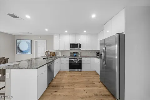a kitchen with stainless steel appliances granite countertop a refrigerator and a sink