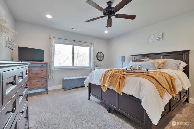 a spacious bedroom with a bed and a chandelier
