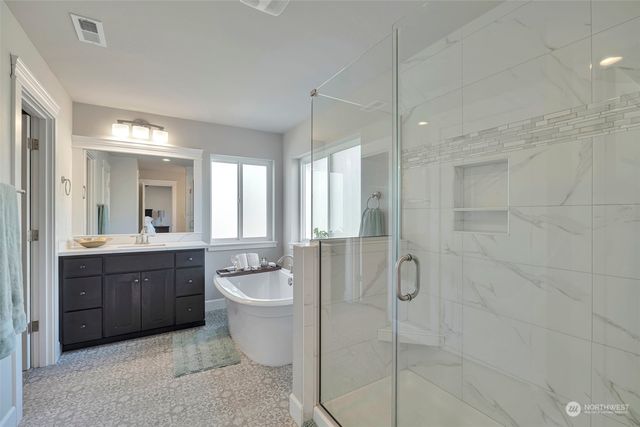 a spacious bathroom with a bathtub shower sink mirror and toilet