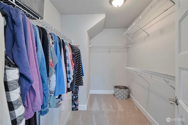 a view of walk in closet with clothes