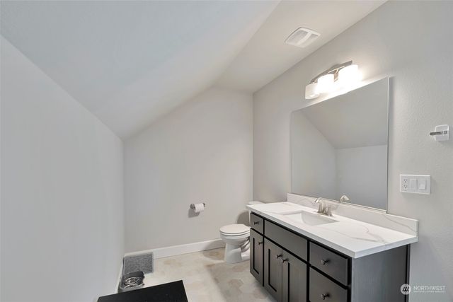a bathroom with a sink vanity and a toilet