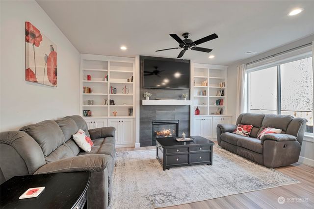 a living room with furniture a fireplace and a flat screen tv