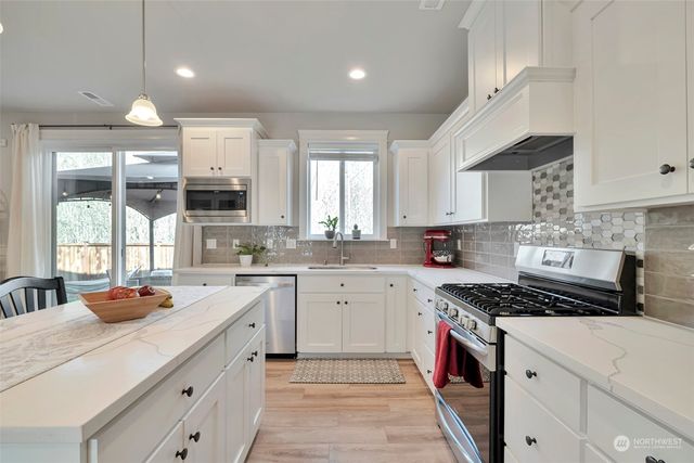 a kitchen with stainless steel appliances a sink stove and cabinets