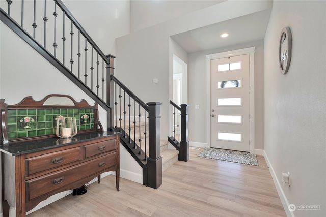 a view of entryway and hall with wooden floor