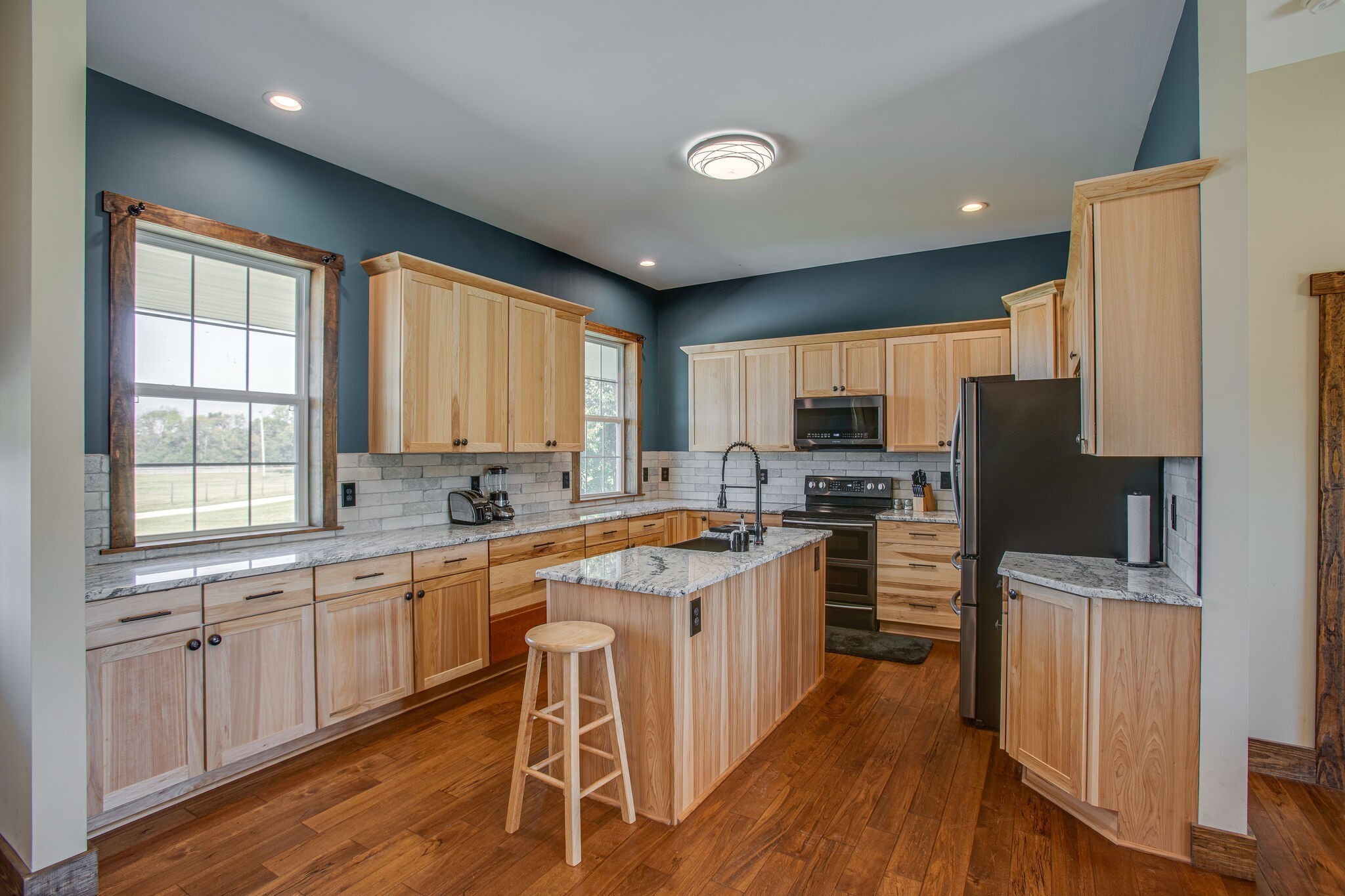 103 Heath Branch Road Chapel Hill, TN 37034 - Photo 11 of 49 a kitchen with stainless steel appliances granite countertop a stove top oven a sink dishwasher a refrigerator and white cabinets with wooden floor