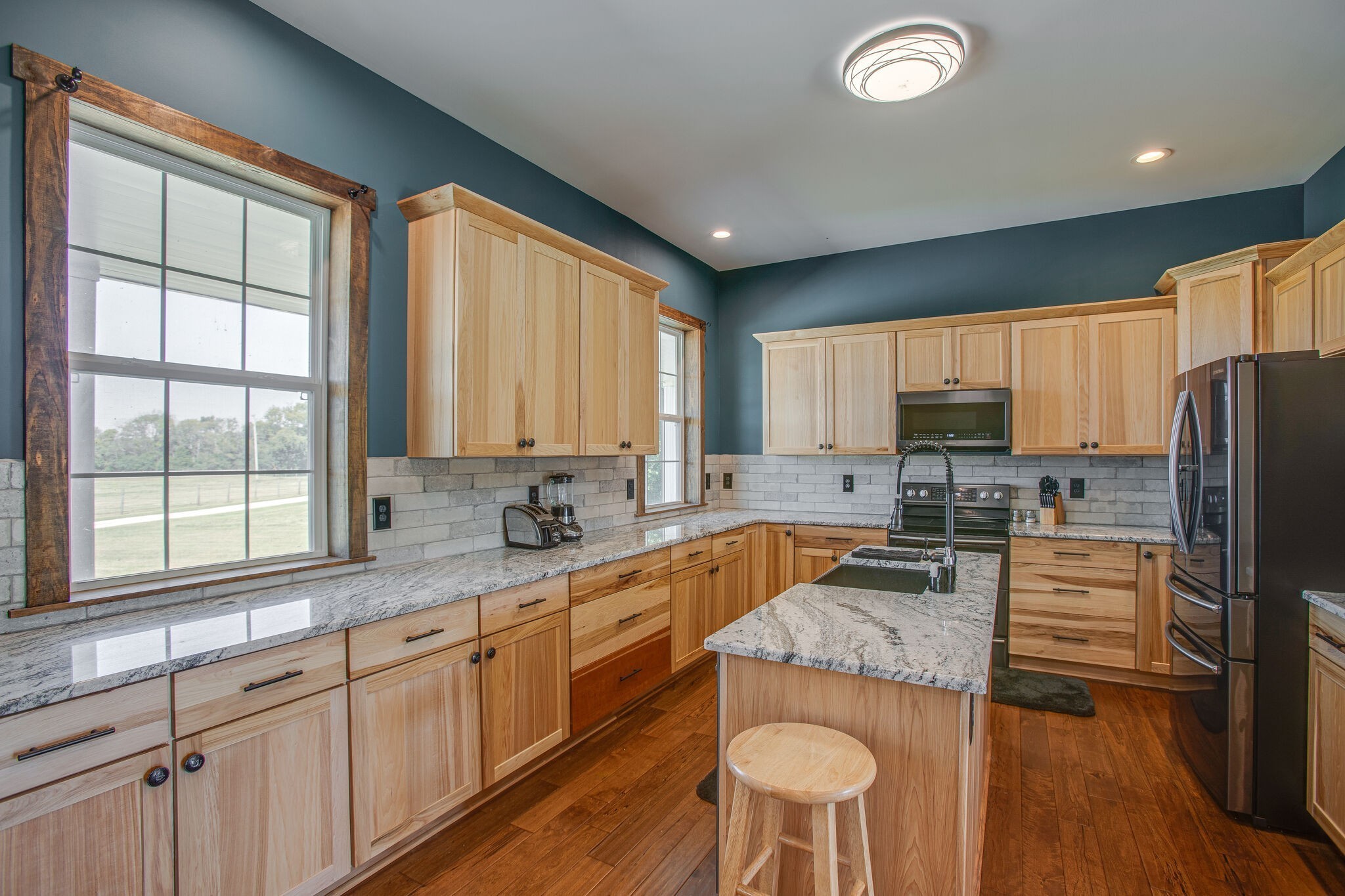 103 Heath Branch Road Chapel Hill, TN 37034 - Photo 12 of 49 a kitchen with granite countertop wooden cabinets a refrigerator a stove a sink and dishwasher with wooden floor