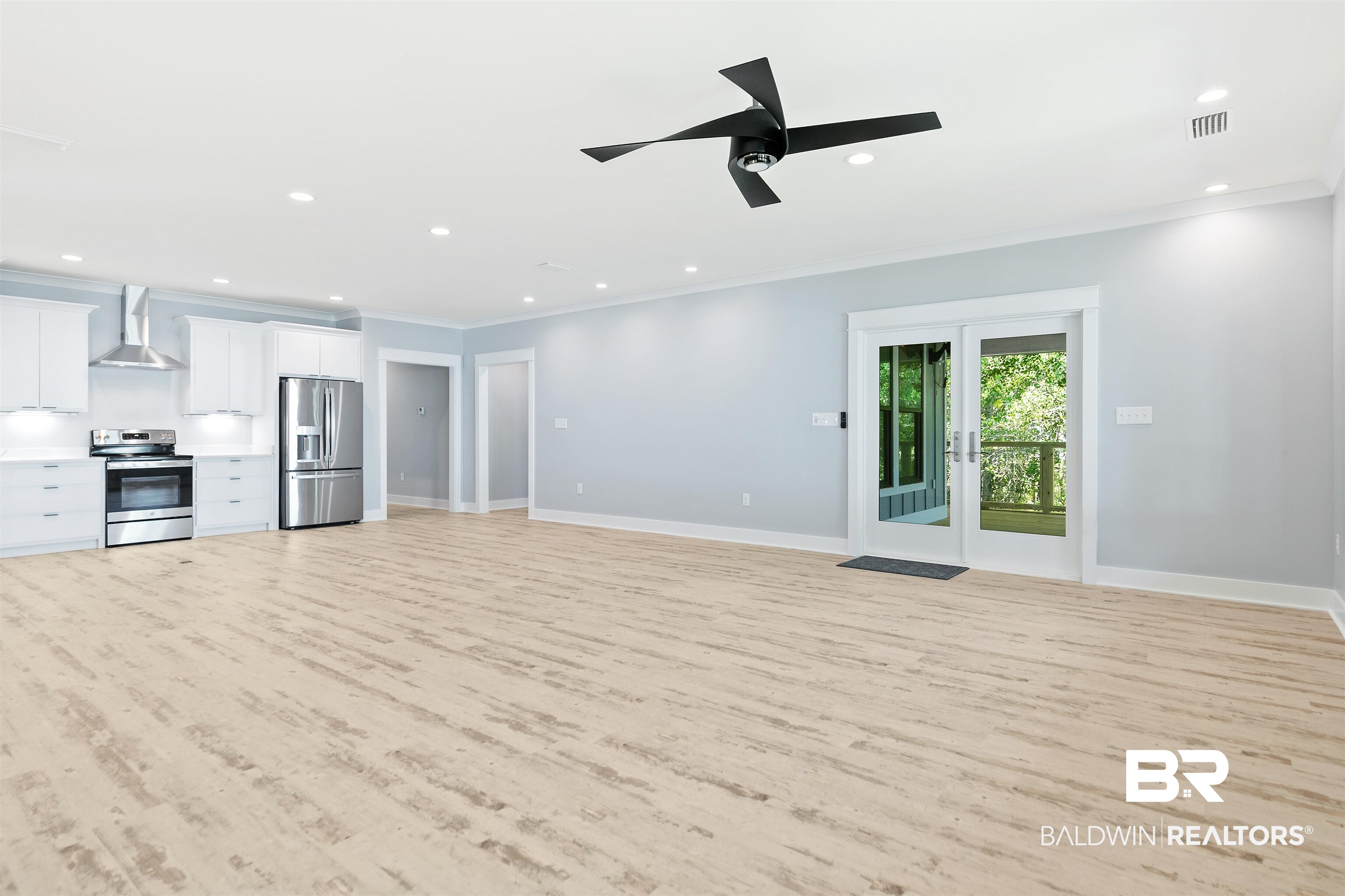10507 County Road 1 Fairhope, AL 36532 - Photo 17 of 59 Unfurnished living room with ornamental molding, light hardwood / wood-style flooring, ceiling fan, and french doors