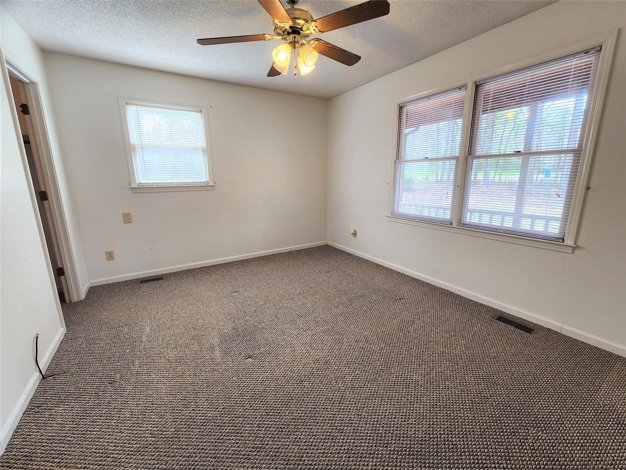 5542 Wagoner Road Gold Hill, NC 28071 - Photo 12 of 34 an empty room with windows and fan
