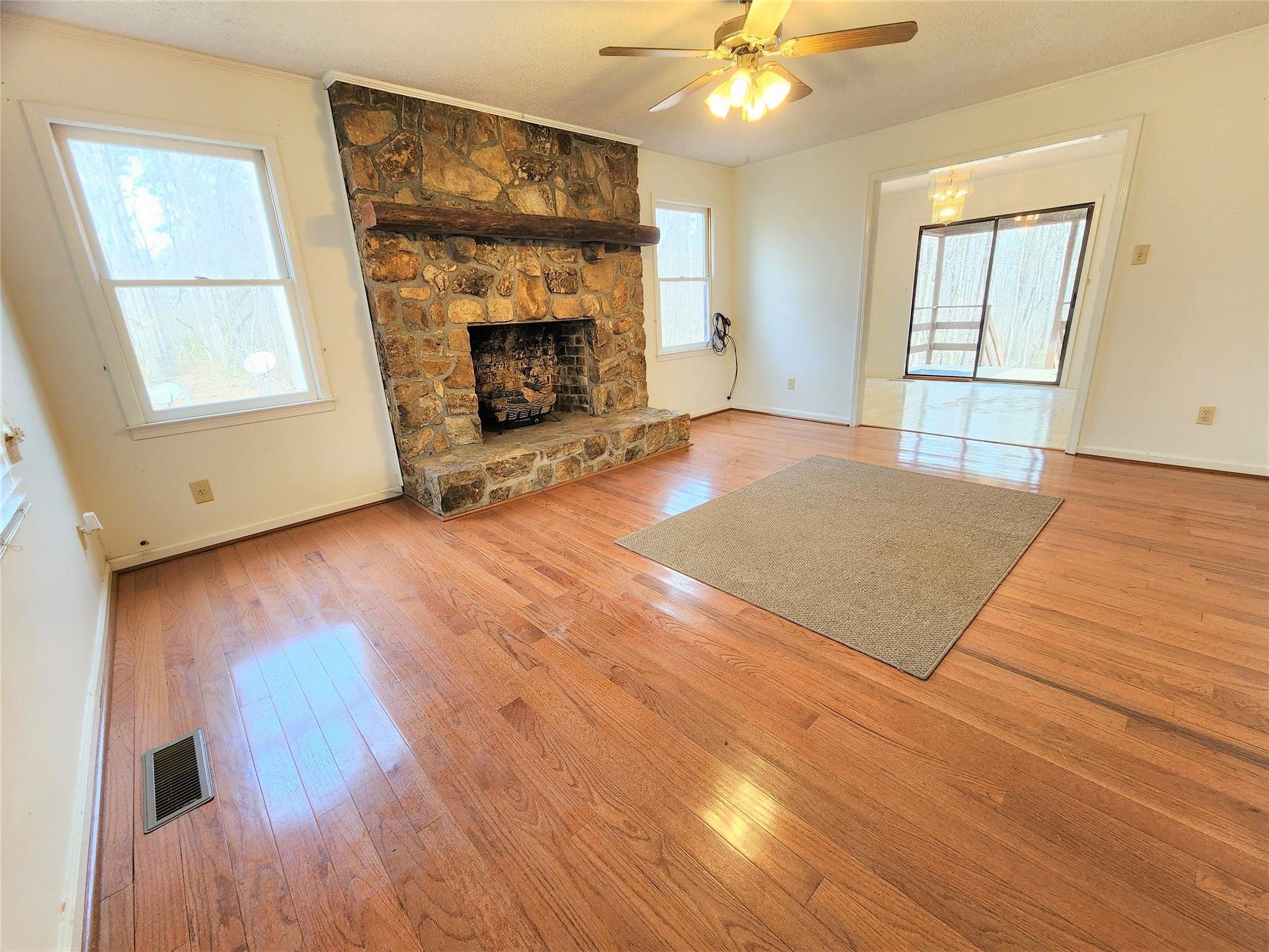 5542 Wagoner Road Gold Hill, NC 28071 - Photo 5 of 34 an empty room with wooden floor fireplace and windows
