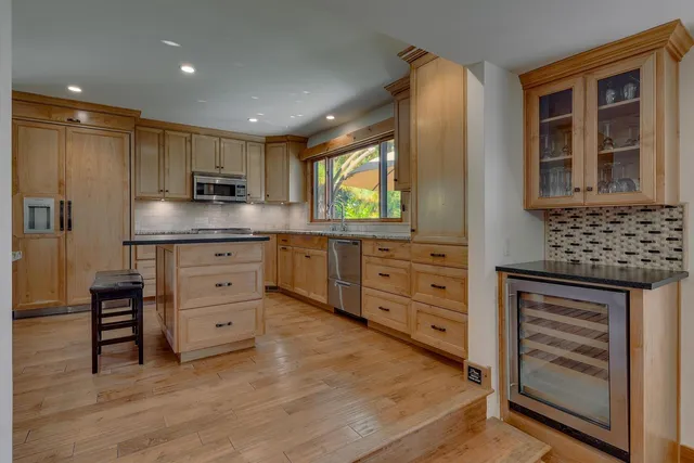 a kitchen with stainless steel appliances kitchen island granite countertop a stove and a sink