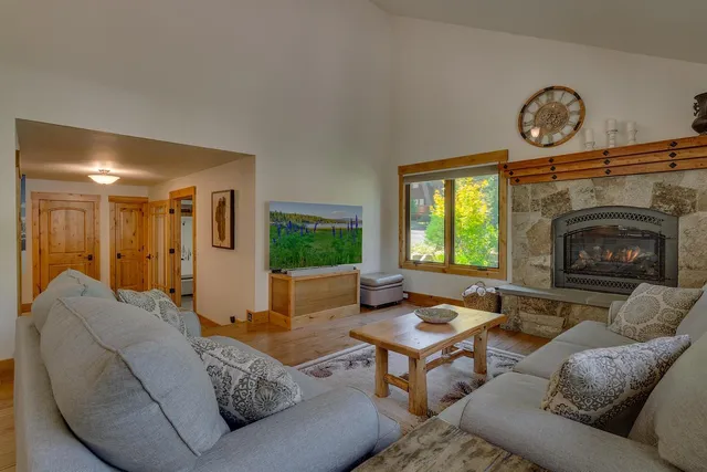 a living room with furniture a fireplace and a large window