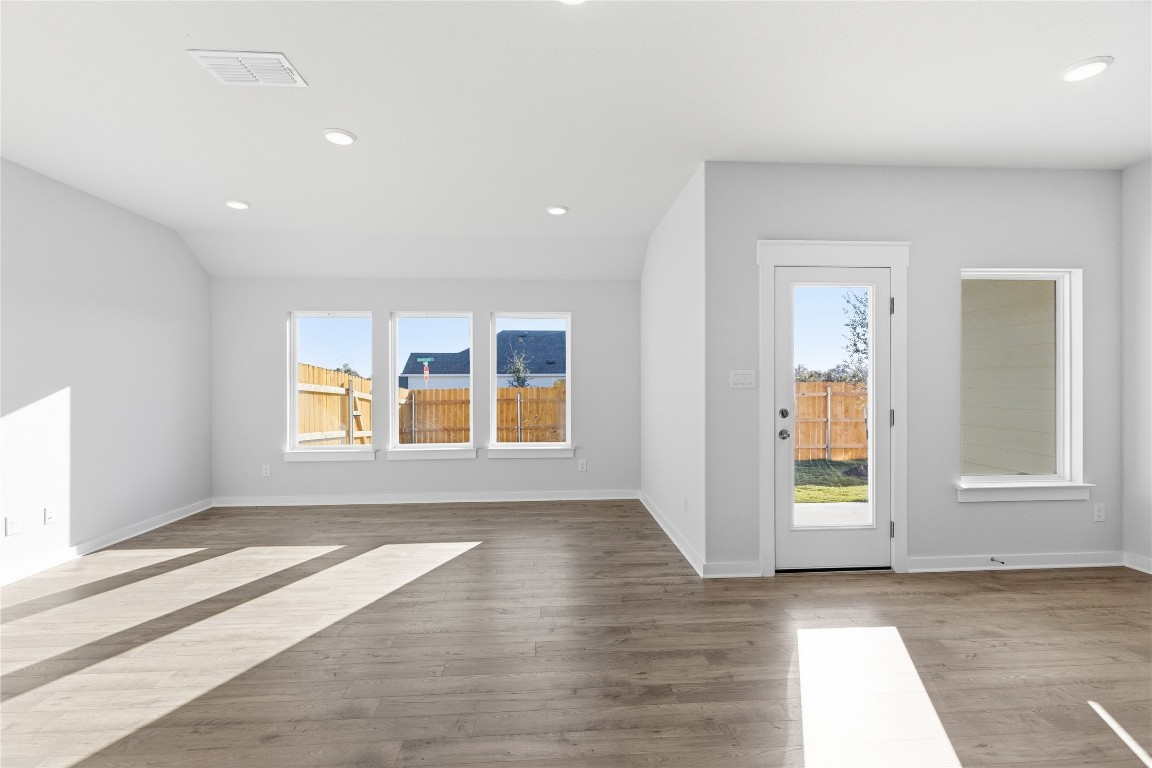 13500 Barn Chime Street Elgin, TX 78621 - Photo 3 of 14 an empty room with wooden floor and windows