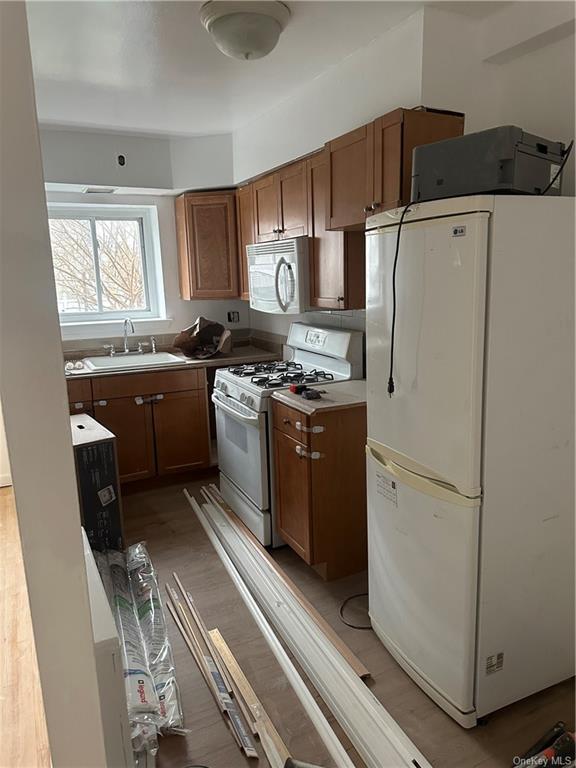 a kitchen with stainless steel appliances granite countertop a refrigerator a sink a stove and white cabinets