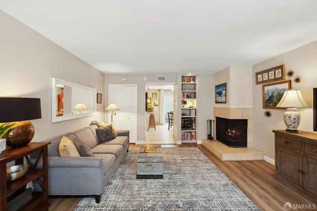 a living room with furniture a fireplace and a flat screen tv