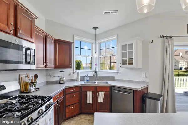 a kitchen with stainless steel appliances granite countertop a stove a sink dishwasher and cabinets with wooden floor