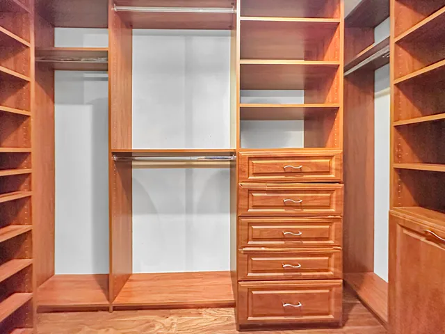 a view of walk in closet with empty racks