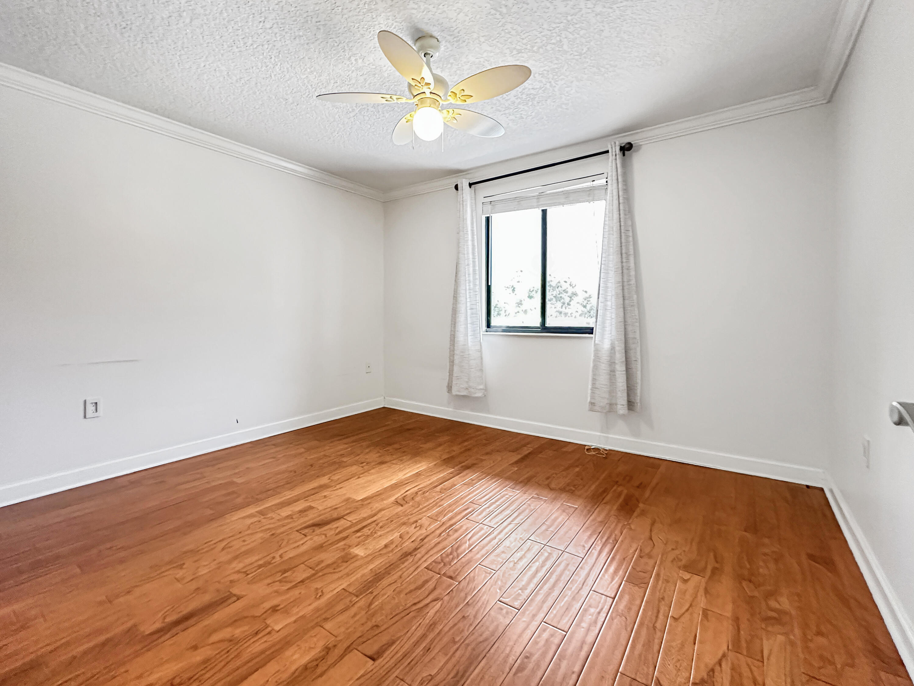 2761 Village Boulevard, Unit 306 West Palm Beach, FL 33409 - Photo 13 of 15 an empty room with wooden floor and windows