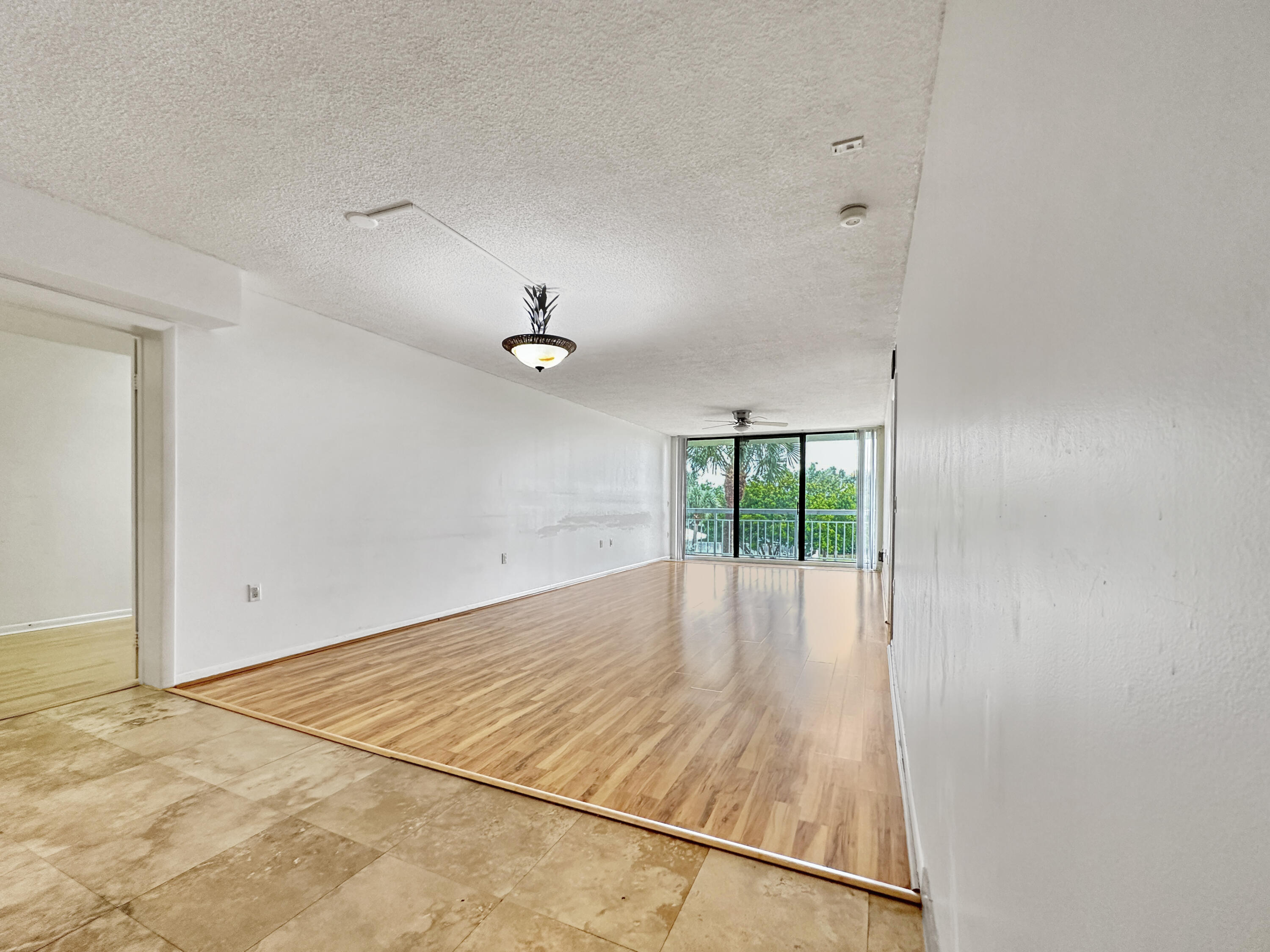 2761 Village Boulevard, Unit 306 West Palm Beach, FL 33409 - Photo 7 of 15 an empty room with wooden floor and windows