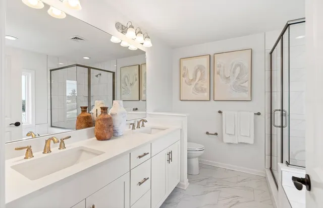 a spacious bathroom with a double vanity sink mirror and toilet