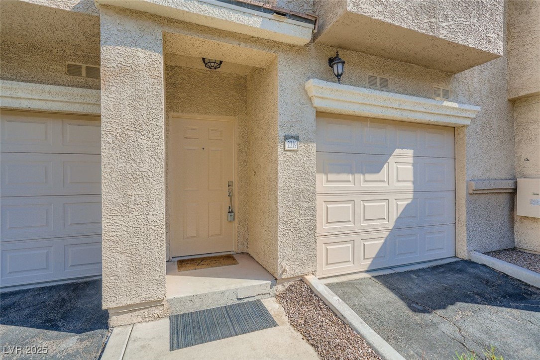 10550 West Alexander Road, Unit 2219 Las Vegas, NV 89129 - Photo 6 of 29 Entrance to property with stucco siding and a garage