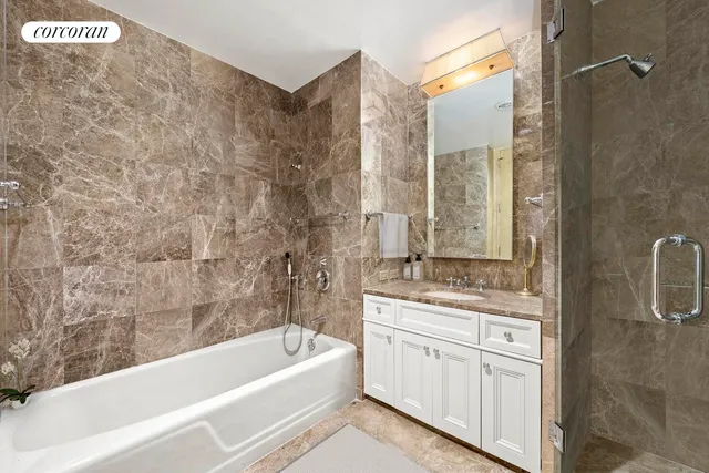 a bathroom with a granite countertop sink a toilet a bathtub and shower