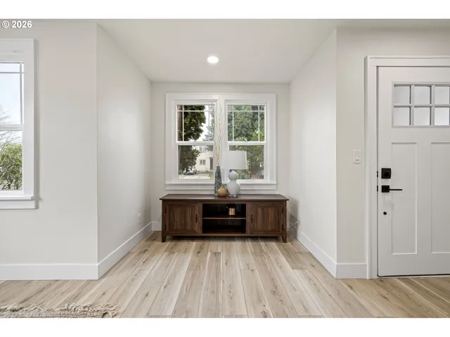 a living room with kitchen island granite countertop wooden floors and wide window