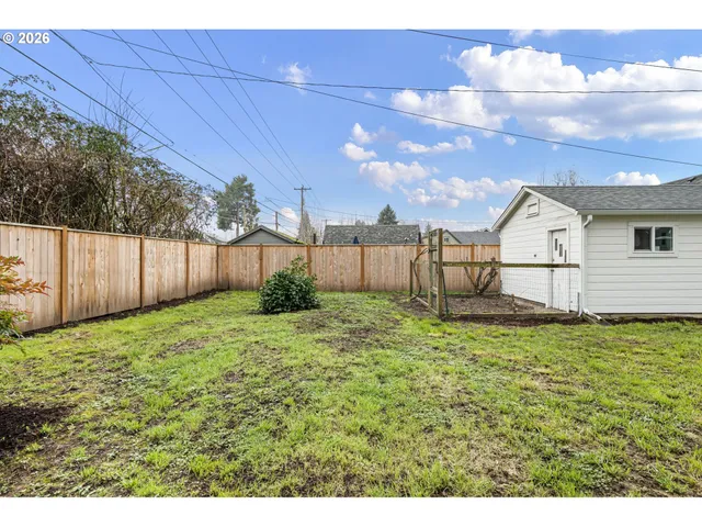 a view of a backyard with wooden fence