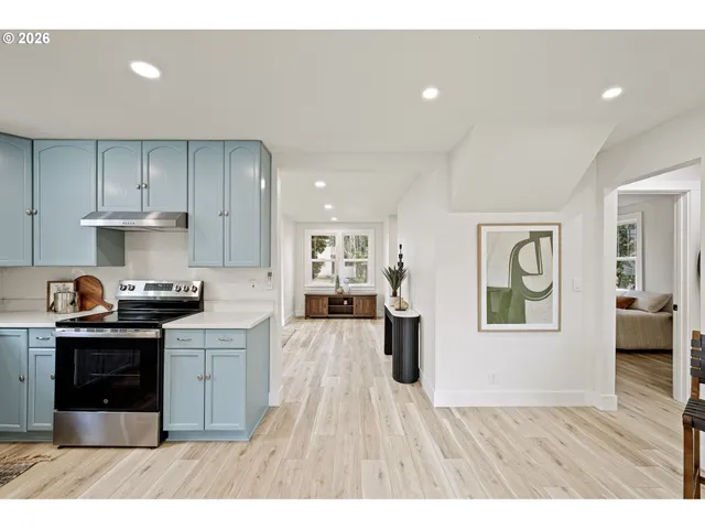 a kitchen with stainless steel appliances granite countertop a refrigerator a stove top oven a sink dishwasher and white cabinets with wooden floor