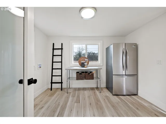 a kitchen with a refrigerator and a wooden floor