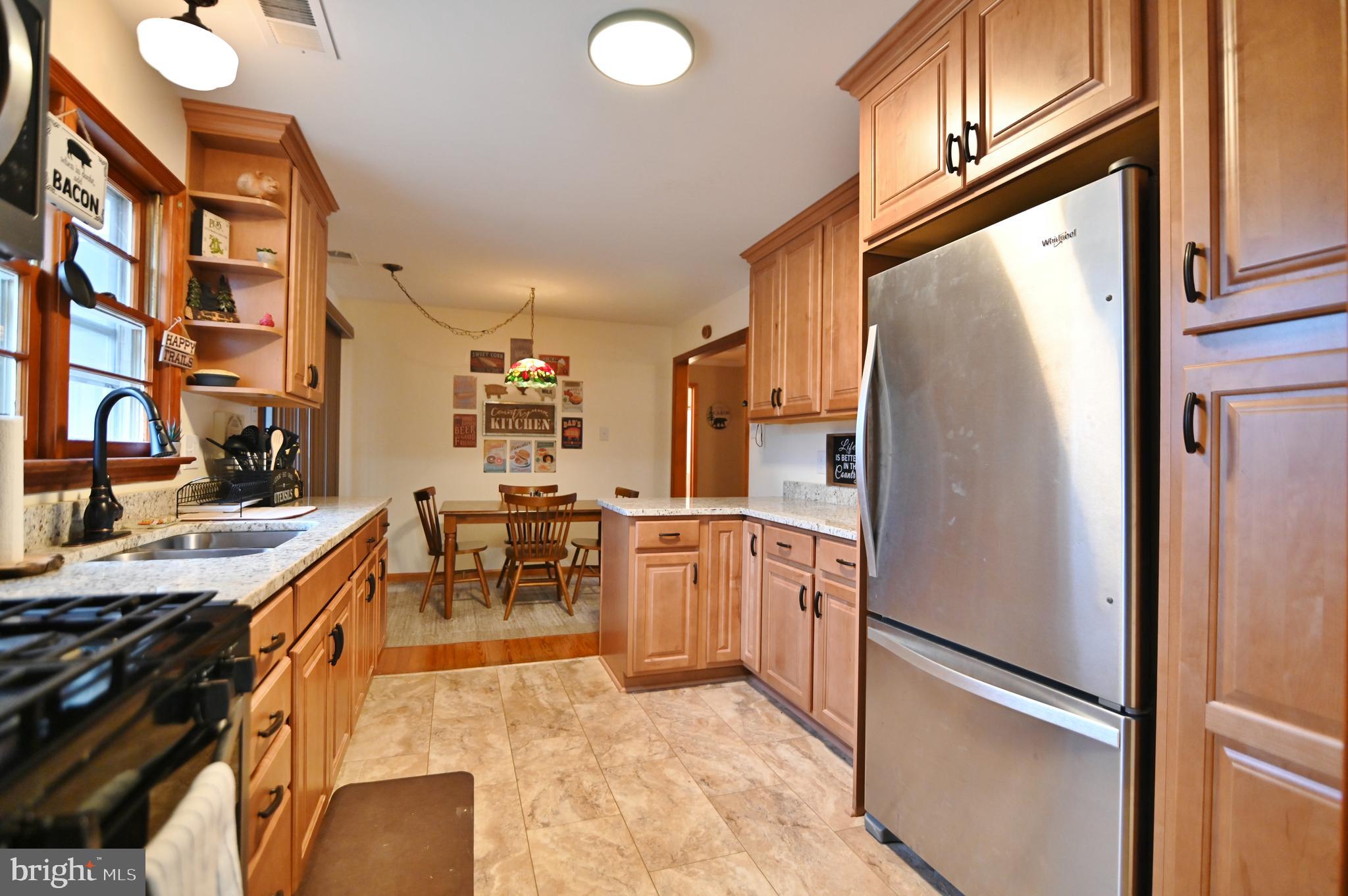 67 Plum Tree Lane Fort Valley, VA 22652 - Photo 23 of 47 a kitchen with stainless steel appliances granite countertop a refrigerator a stove and a sink with cabinets