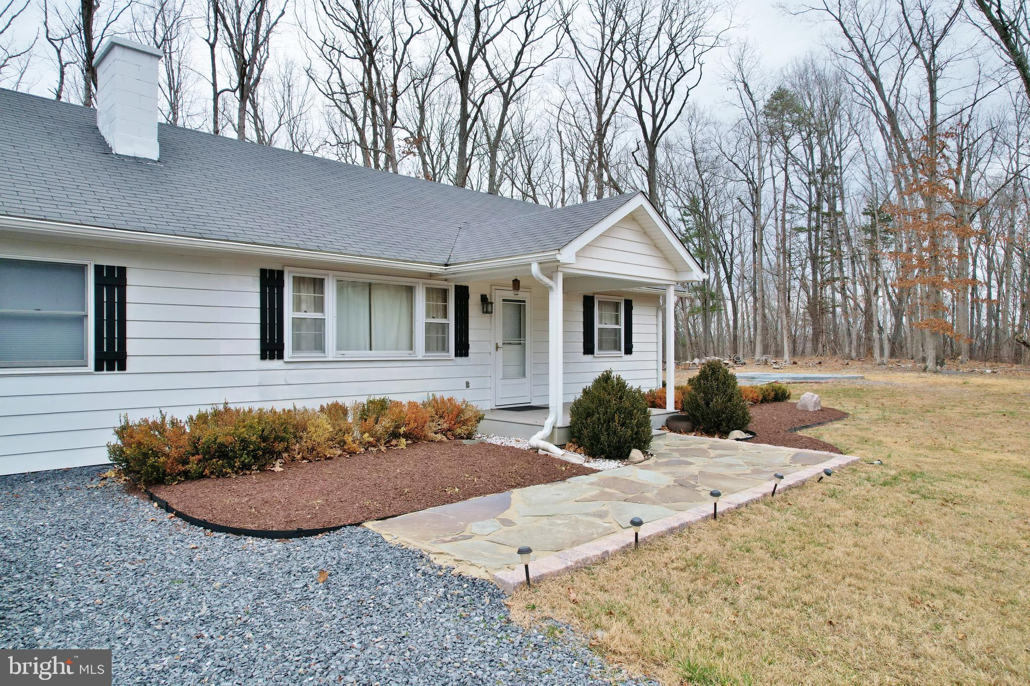 67 Plum Tree Lane Fort Valley, VA 22652 - Photo 5 of 47 a front view of a house with a yard outdoor seating and covered with trees