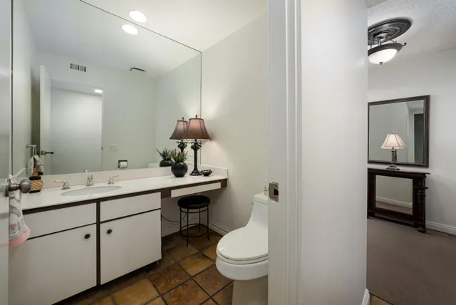 a bathroom with a toilet sink and mirror