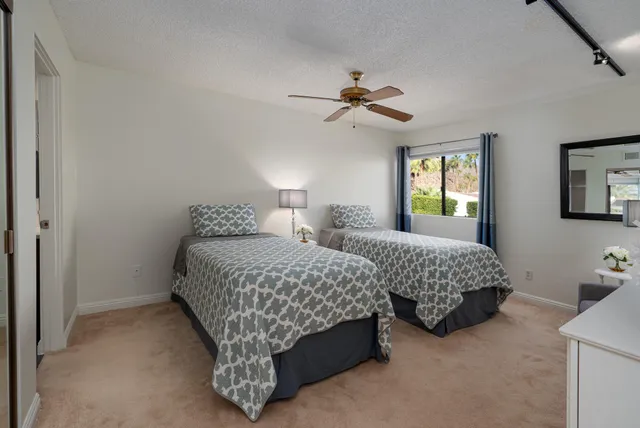 a bedroom with two beds and a chandelier